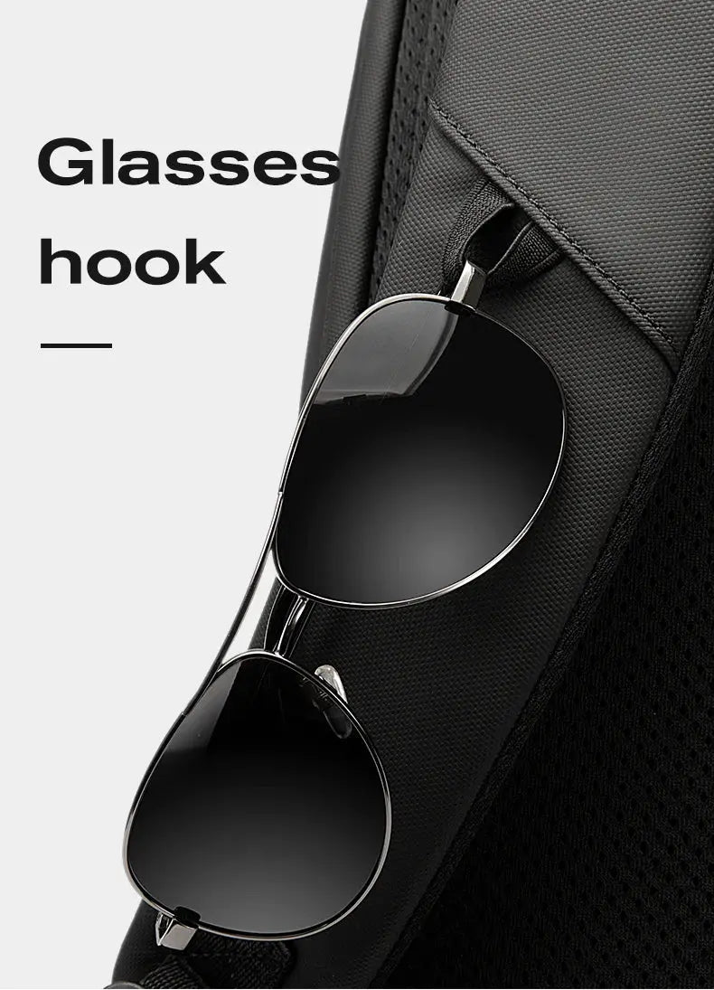 Black laptop backpack with sunglasses clipped to the strap