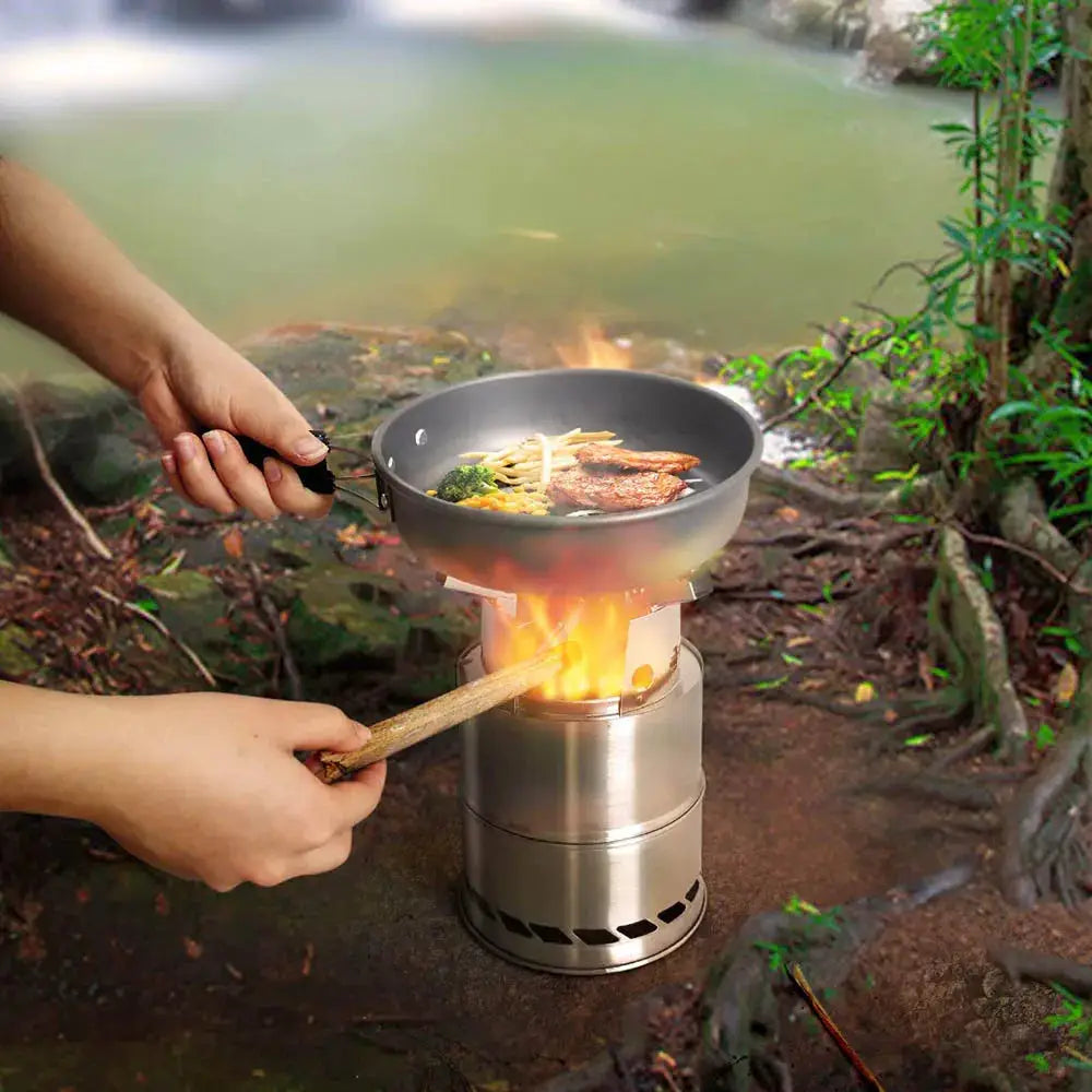 Portable outdoor camping stove wood-burning, stainless steel, compact cook stove with pan on top.