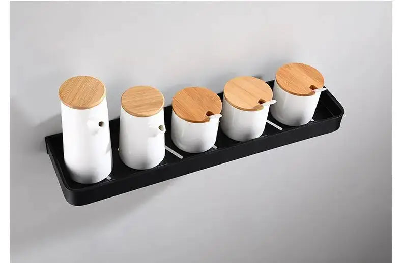 Simples Market black aluminum wall-mounted bathroom shelf with five white canisters and wooden lids.