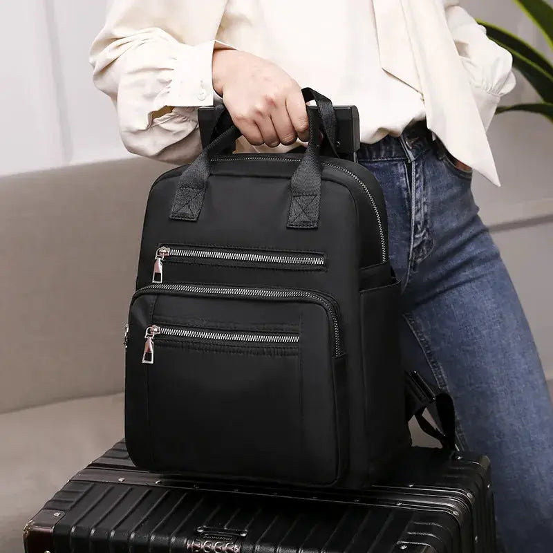 Simples Market women's black waterproof Oxford backpack with multiple zip pockets for large capacity.