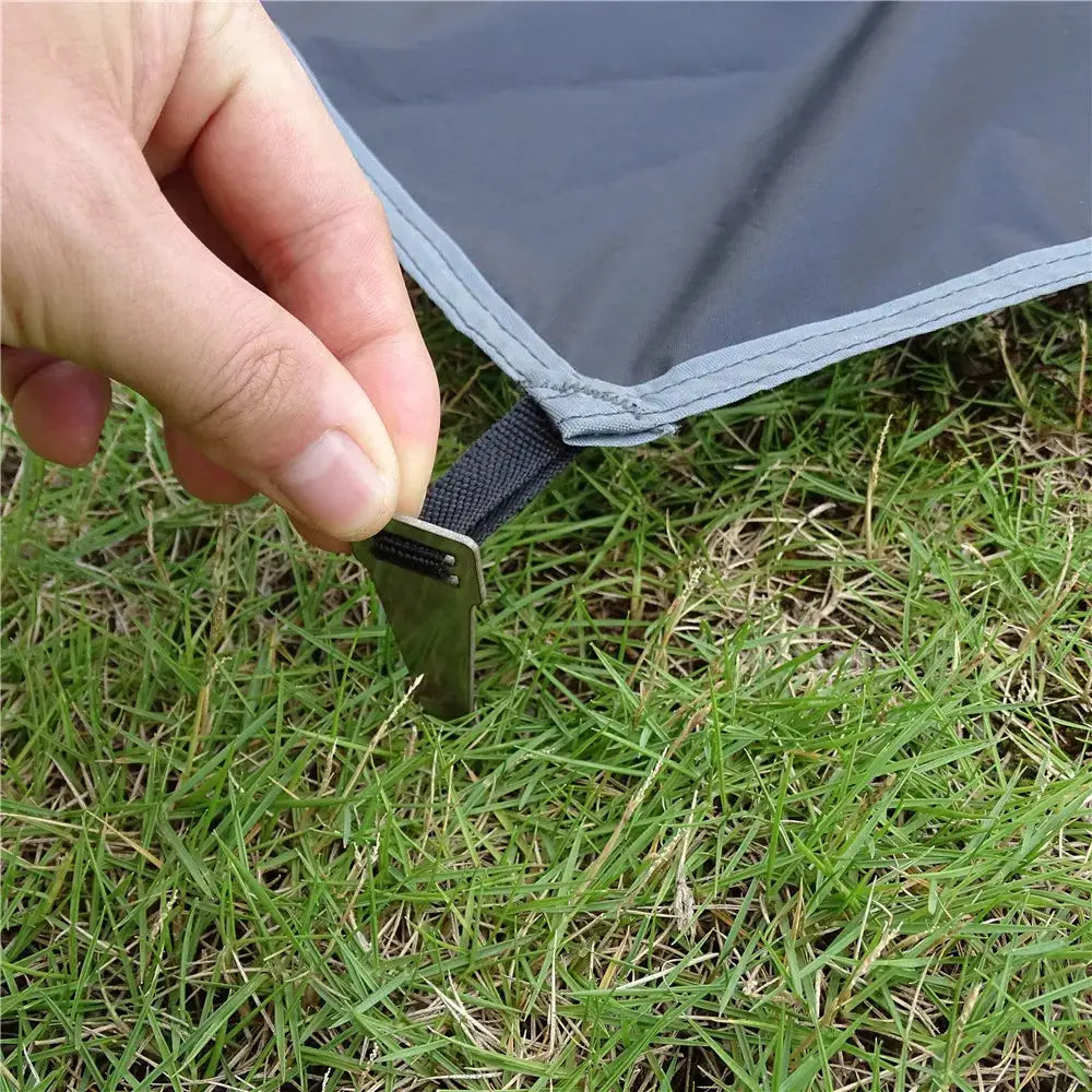 Simples Market waterproof camping mat with peg and strap; gray ultralight travel beach mat on grass.