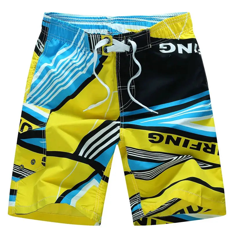 Men's surf board shorts in bright yellow, blue, and black with white drawstring and bold graphic print
