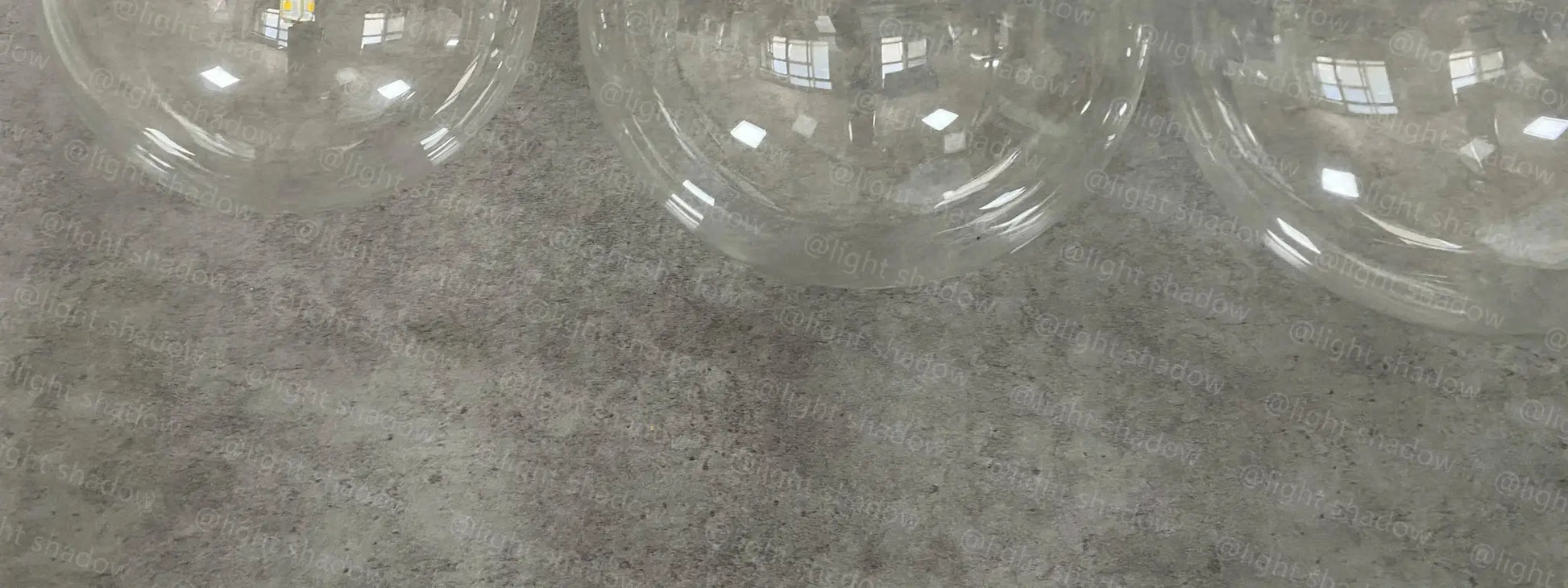 Glass ball LED pendant lamps; several clear glass spheres hanging in a modern Nordic-style living decor.