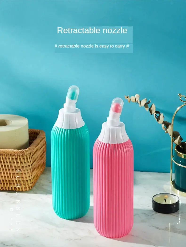 Two portable bidets with retractable nozzles, teal and pink, on a marble surface.