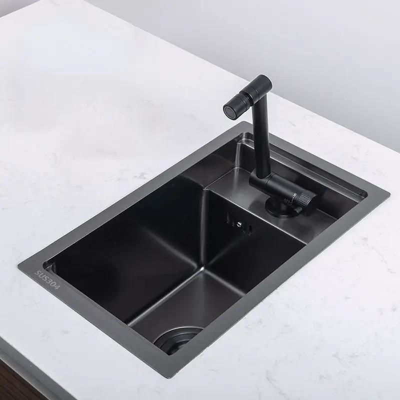 Compact black single-bowl kitchen sink with matte black faucet and stainless-steel rim