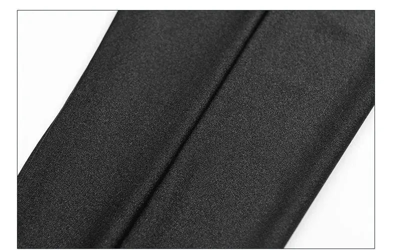 Women's black stretch leggings close-up showing shiny fabric.