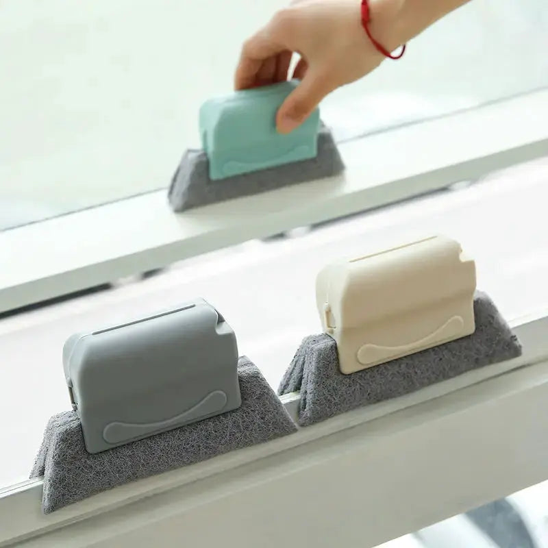 Groove cleaning brush by Simples Market; three color variants (gray, beige, turquoise) shown on foam bases.