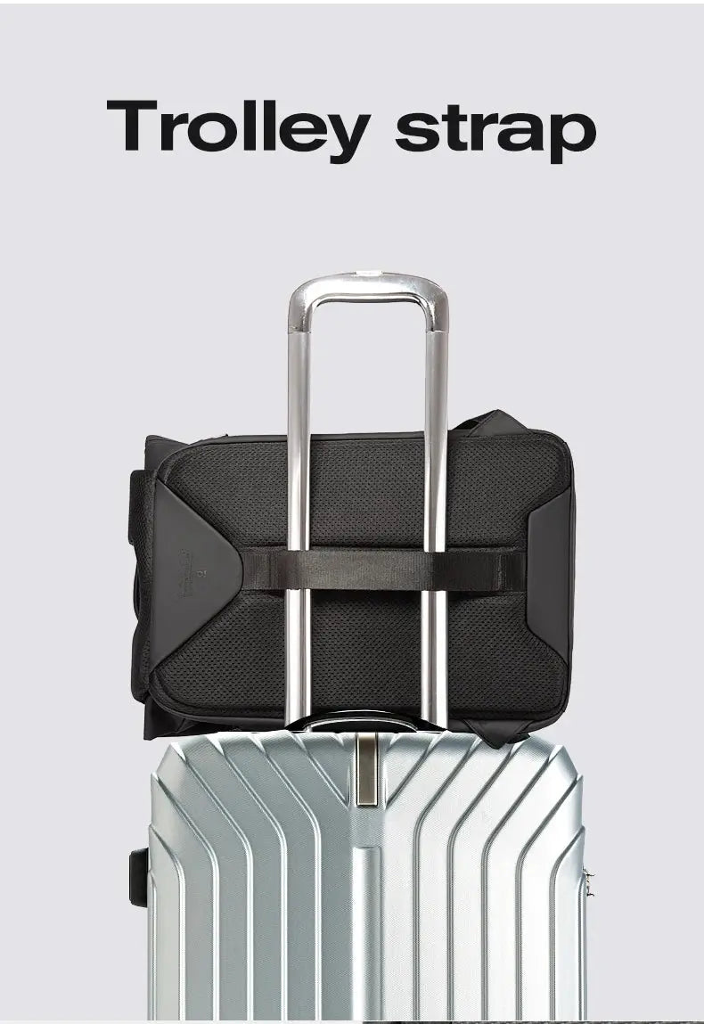 Anti-theft waterproof laptop backpack, black, 15.6-inch compatible, shown atop a silver trolley suitcase