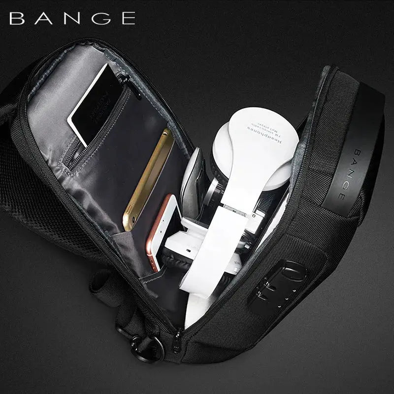 BANGE anti-theft chest bag in black with USB charging pocket, opened to reveal phone, headphones, and cards.