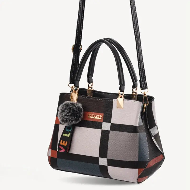 Simples Market plaid PU leather handbag with top handles and crossbody strap, gold hardware and fur pom keychain.