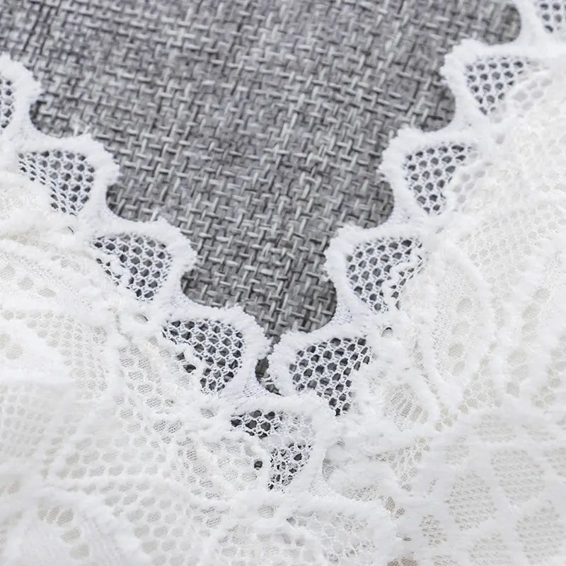 White lace bralette close-up with scalloped edges and sheer mesh.
