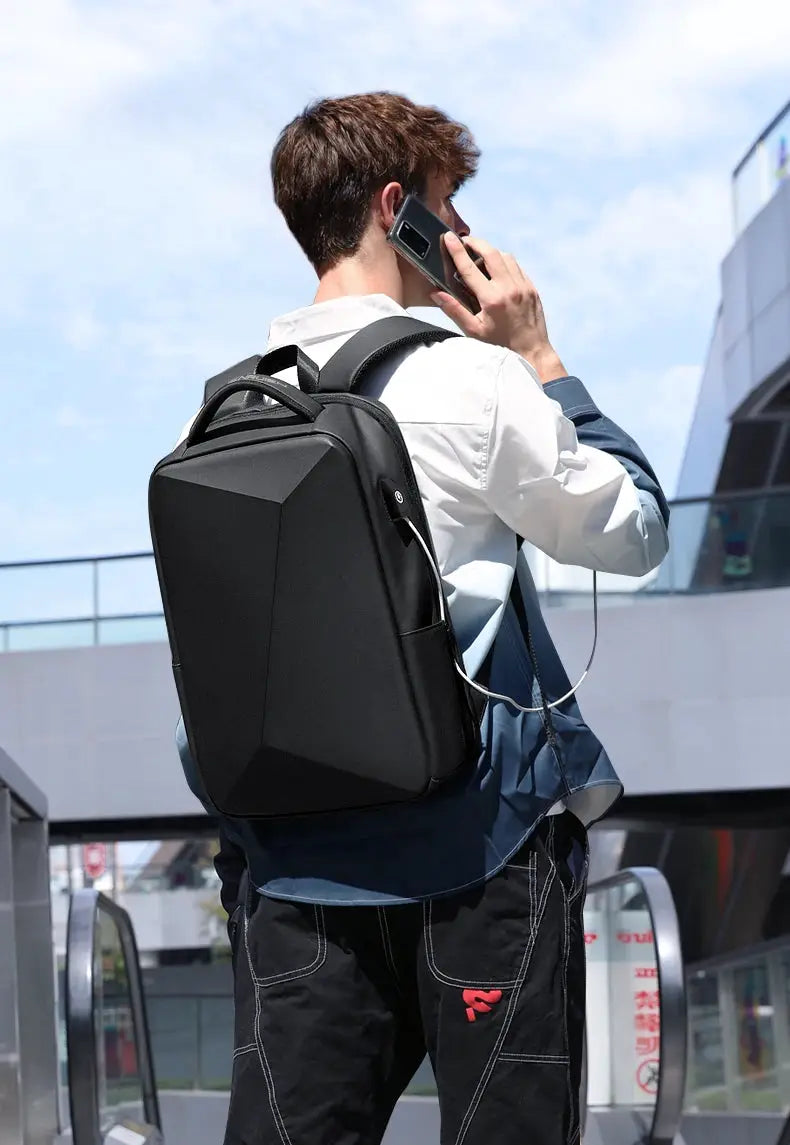 Fenruien laptop backpack in black with USB charging port worn by a man outdoors