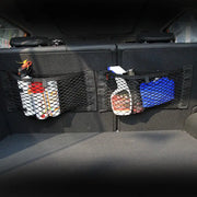 Trunk storage net bags for Audi models; two black rear-seat organizers attached to seat backs holding bottles and a blue container