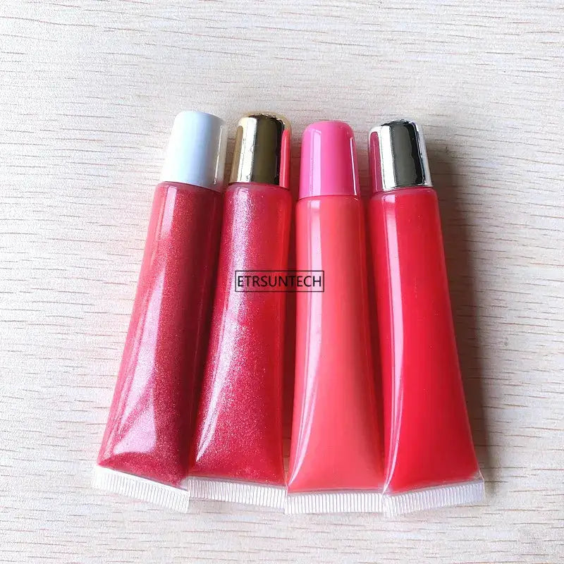 Set of four empty lipstick tubes with colored caps and clear bodies for lip gloss or balm storage.