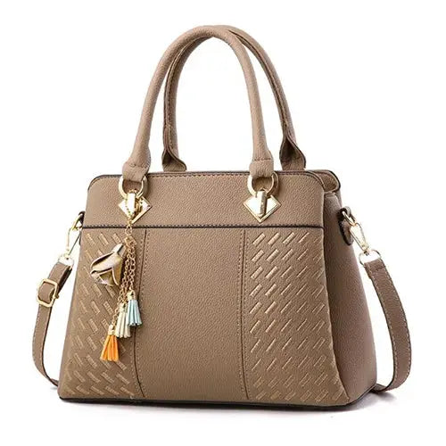 Women's taupe PU leather tote handbag with tassel charms, top handles and crossbody strap