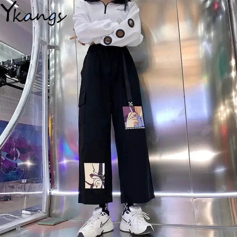 White mid-sleeve blouse with circular sleeve cutouts; two-piece outfit with black cargo wide-leg pants featuring patches