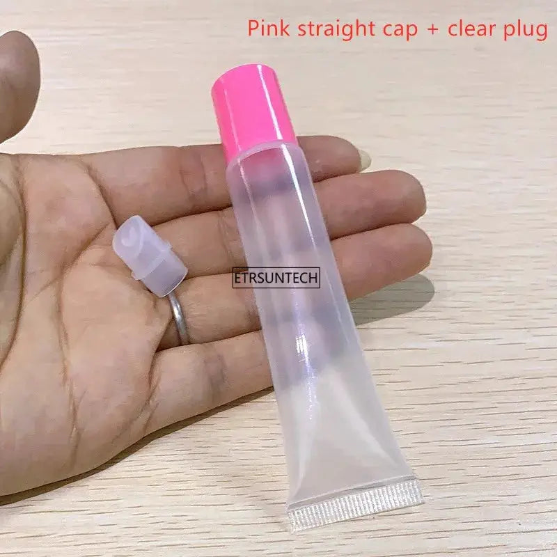 Clear plastic lipstick tube with pink cap, empty lip gloss container