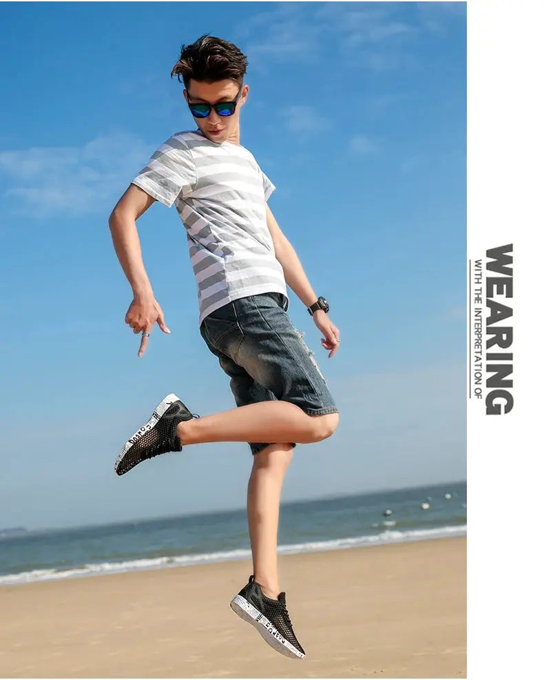 Simples Market water shoes; black air-mesh sneakers with foam sole worn by man at the beach.