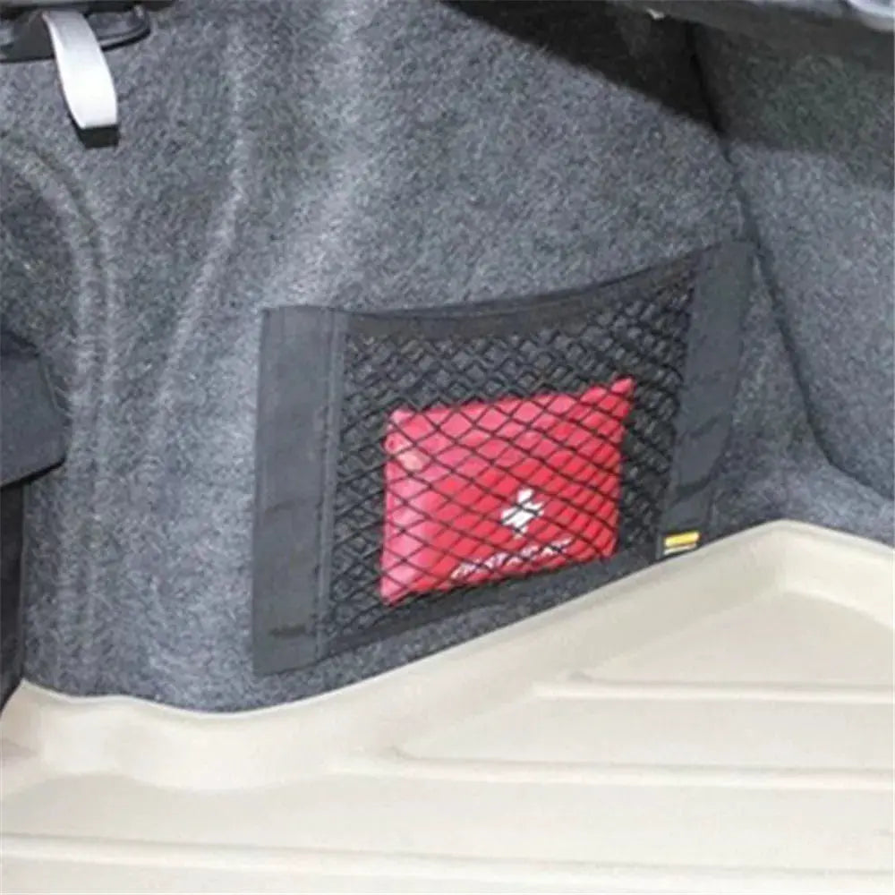 Car trunk storage net bag in black mesh with a red item inside