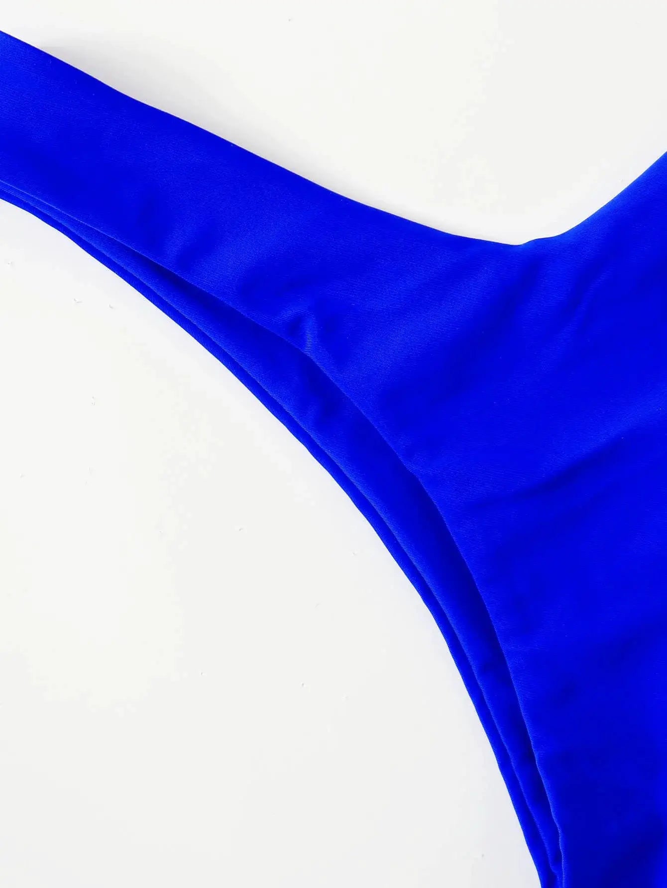 Bikini top in solid blue fabric; close-up view of smooth stretch material