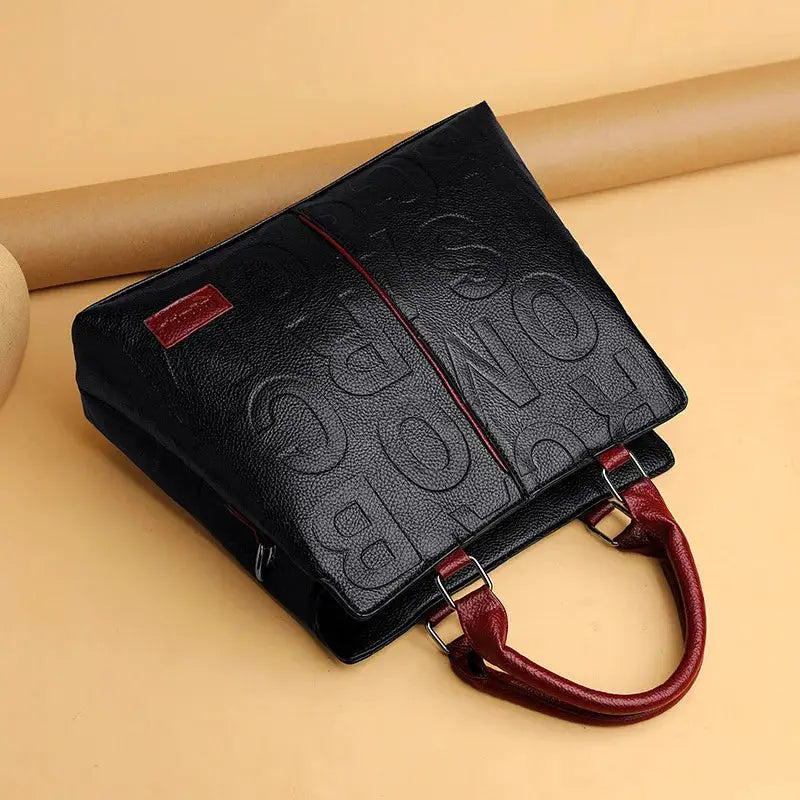PU leather crossbody bag for women, black with embossed pattern and red handles, large capacity tote