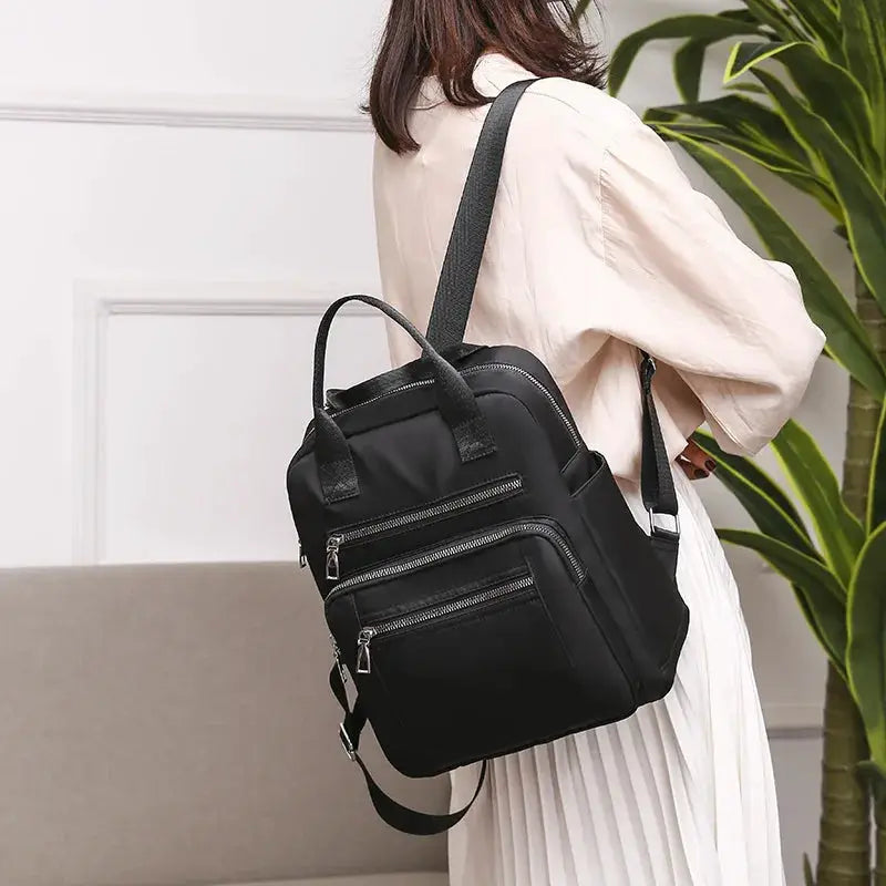 Black women's Oxford backpack with multiple zip pockets and top handles.