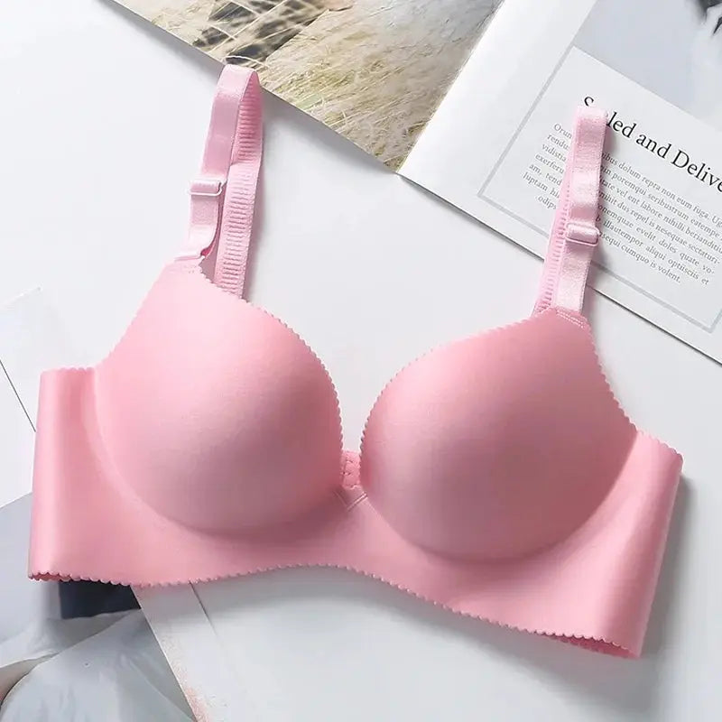 Pink seamless wireless push-up bra with molded cups and adjustable straps.