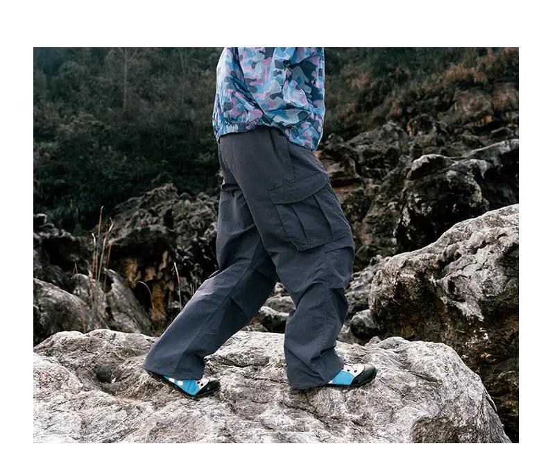 Ultra loose outdoor cargo pants, dark gray, wide-leg with cargo pockets on rocky terrain