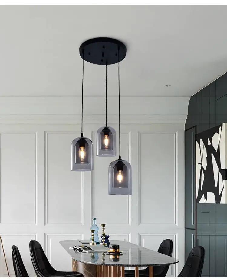 Led pendant lamp Nordic gray glass, three dome pendants on black cords over a dining table.