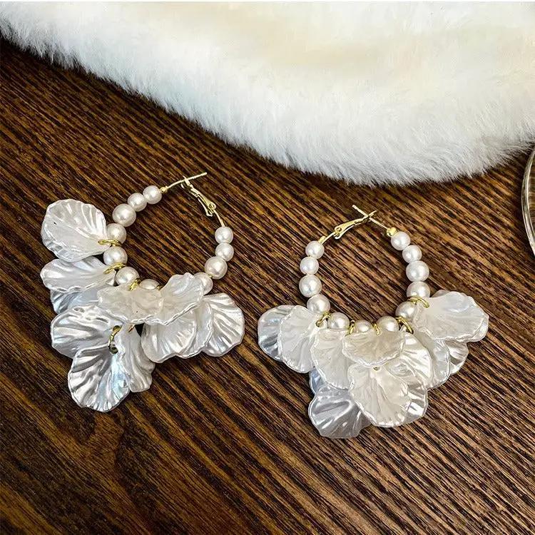 Pair of pearl hoop earrings with glossy shell flower petals and gold-tone trim