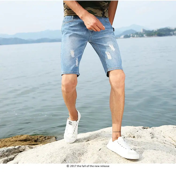 Men's light blue distressed denim shorts, knee-length, casual summer wear.