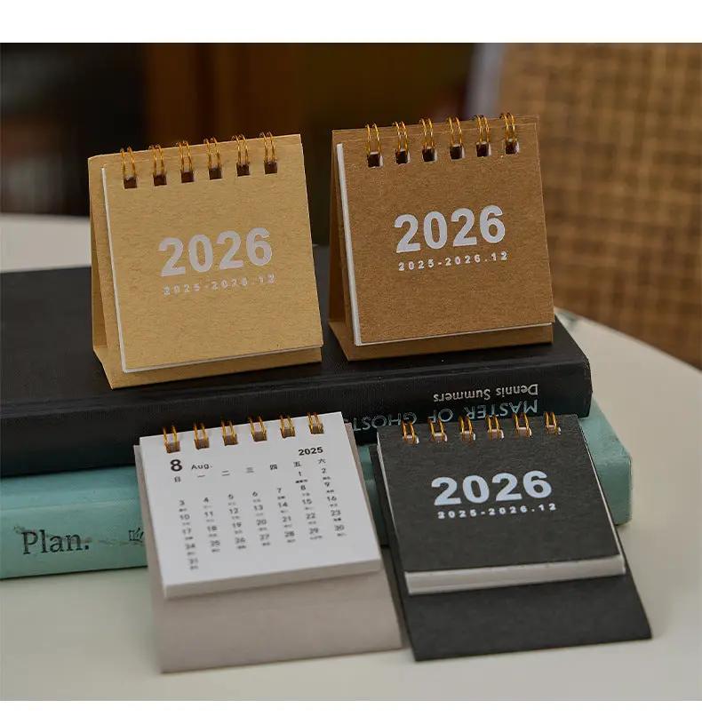Set of four mini 2026 desk calendars with spiral bindings in kraft, white, and black.