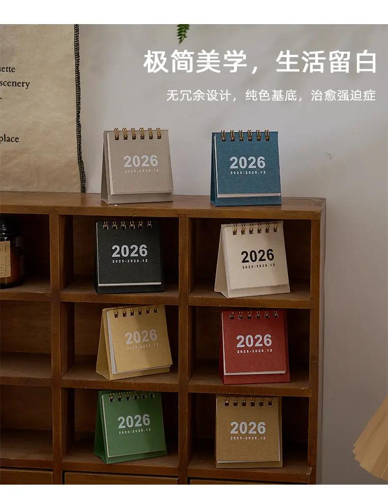 Mini desk calendar set, 2026, coil-bound, with assorted colors displayed on a wooden shelf