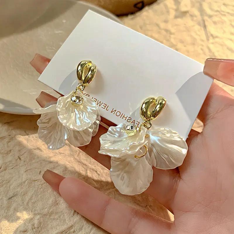Pair of Simples Market glossy shell flower pendant earrings with pearl-like petals and gold-tone tops