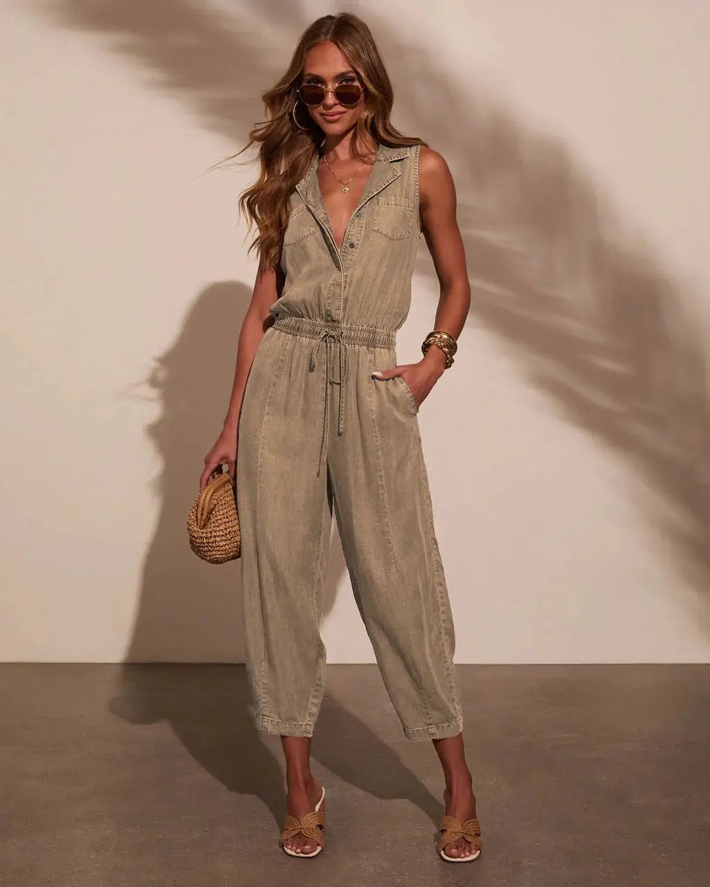 Women sleeveless denim jumpsuit with drawstring waist, front pockets and button-front; light wash casual overalls.