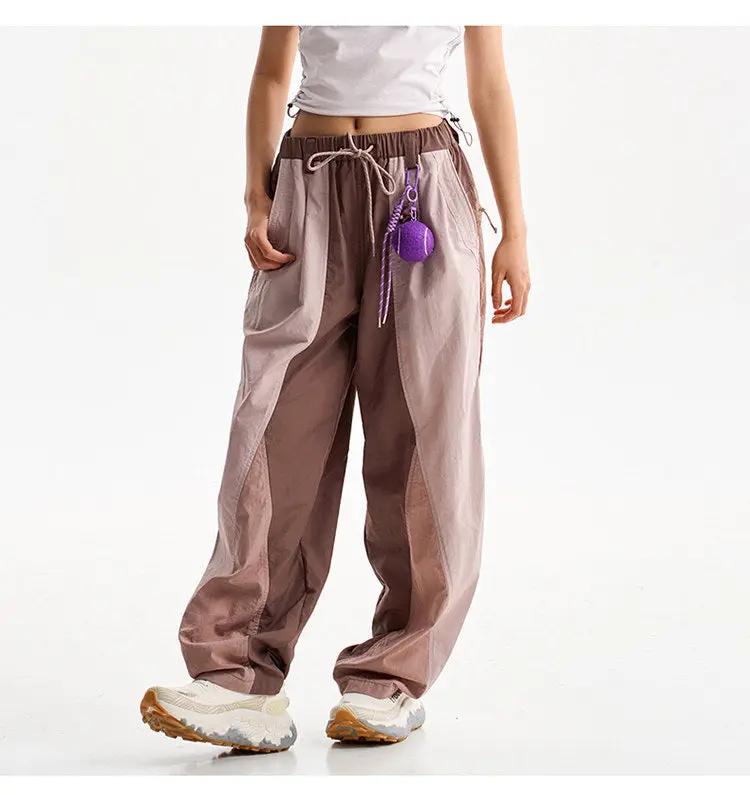 Simples Market wide-leg cargo pants; beige/brown splice panels, drawstring waist, purple accessory.