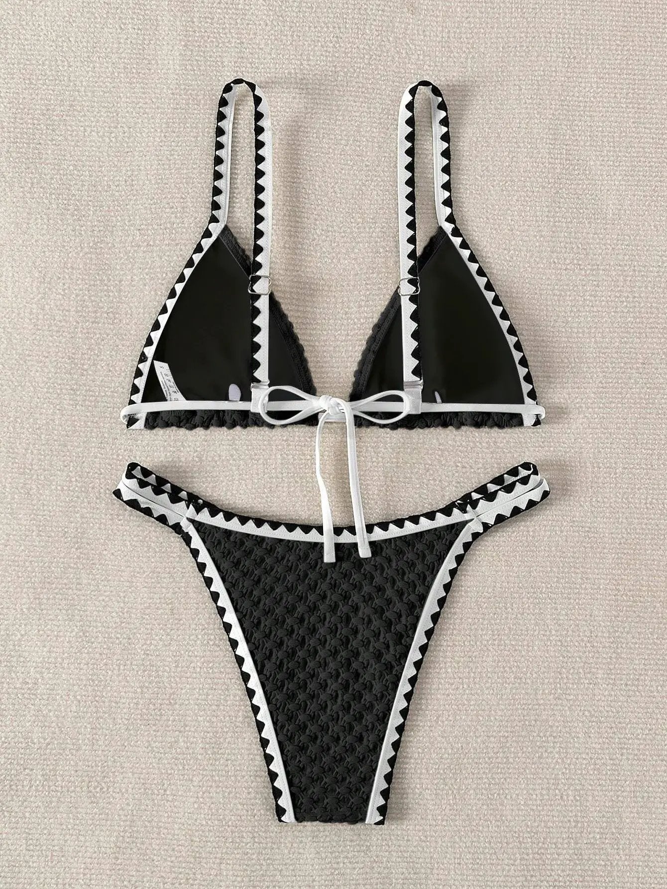 Bikini set by Simples Market in black and white with strapless bandeau top, lace-edge trim and high-cut bottoms
