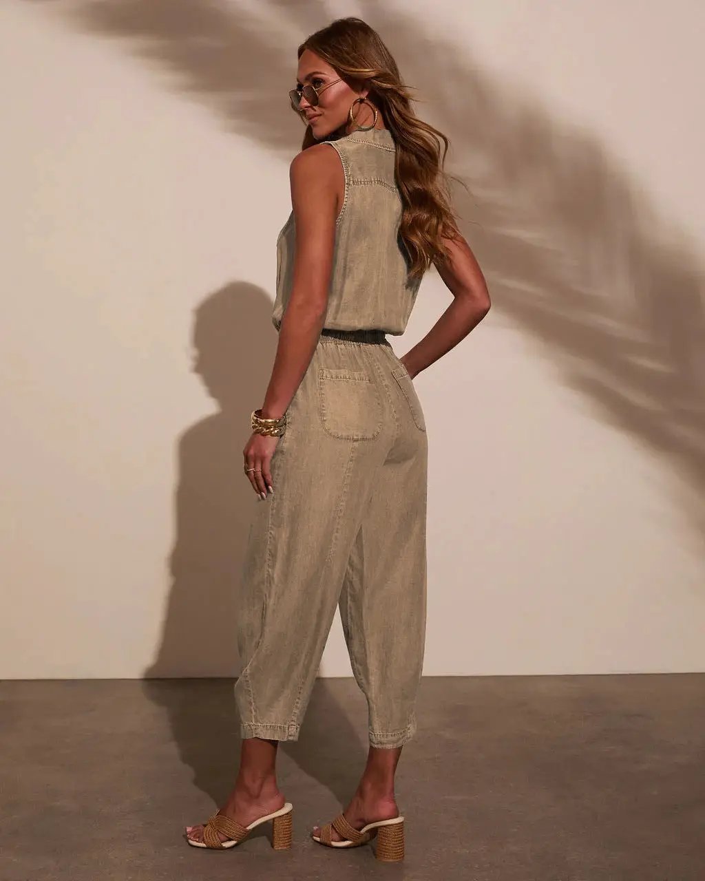 Women’s sleeveless denim jumpsuit in light beige with a drawstring waist and pockets