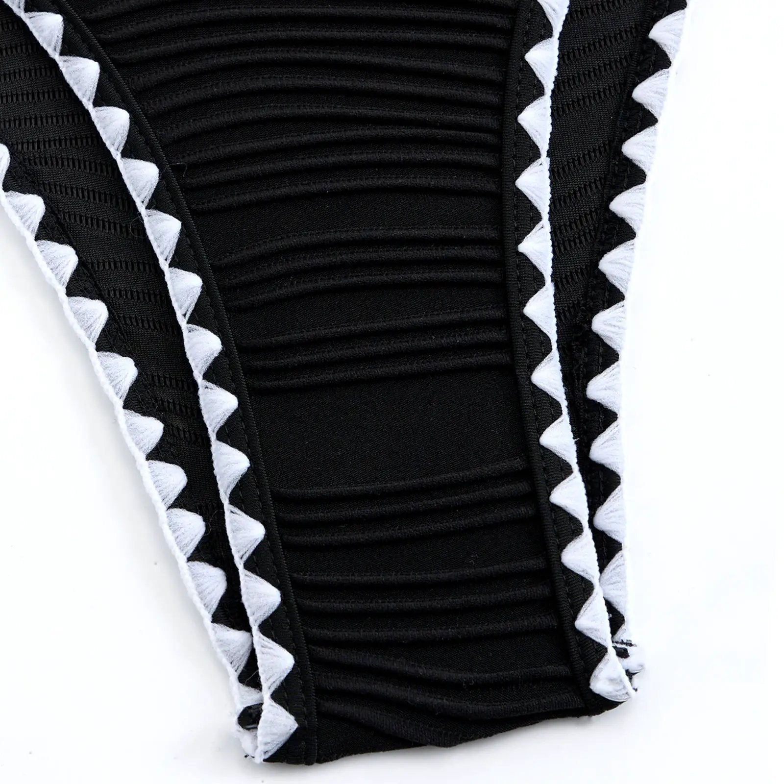 Swimwear fabric detail: black textured panel with white triangular edging.