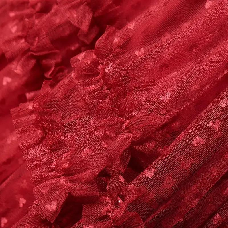 Red mesh heart-printed skirt fabric close-up with tulle texture