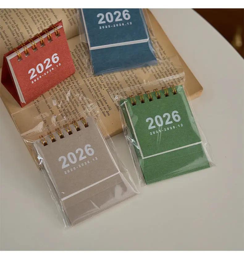 Simples Market mini 2026 desk calendar set of 4 in red, blue, beige, and green with coil bindings