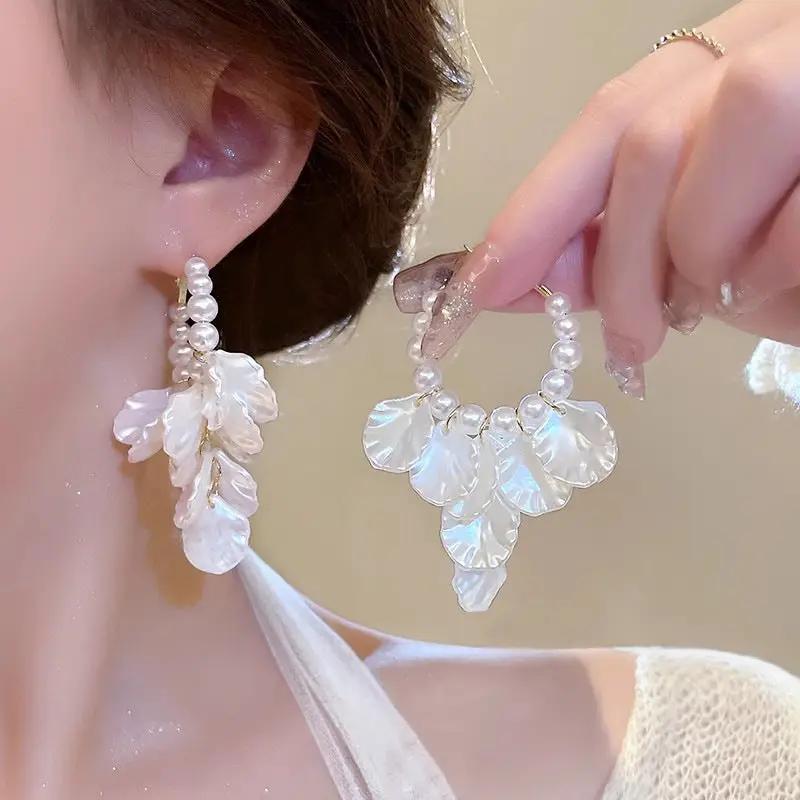 Pair of white pearl and glossy shell flower pendant earrings with shell petal clusters