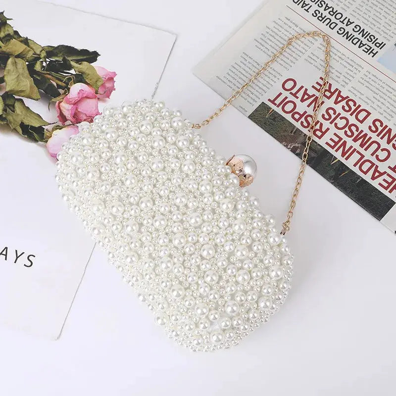 Handcrafted pearl evening bag by Simples Market with a gold chain strap, ivory beaded clutch