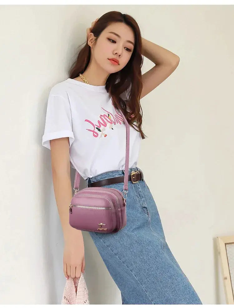 Simples Market pink leather crossbody purse with multiple zip pockets and adjustable strap.