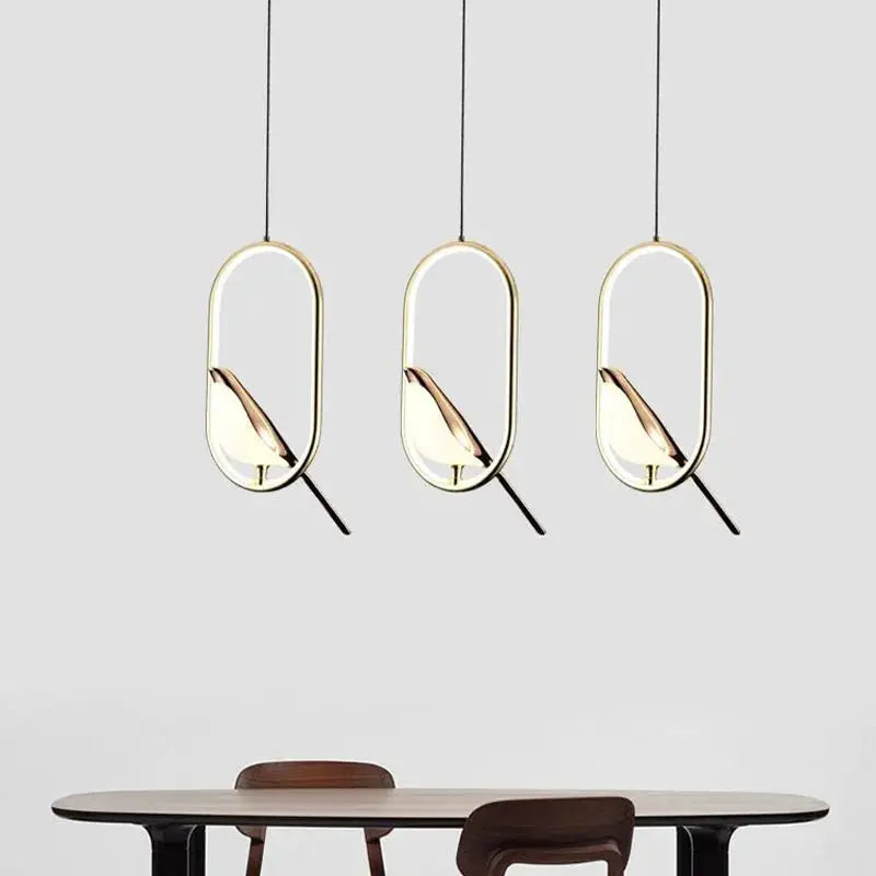 Rotatable magpie bird LED pendant light trio in gold finish for dining room.