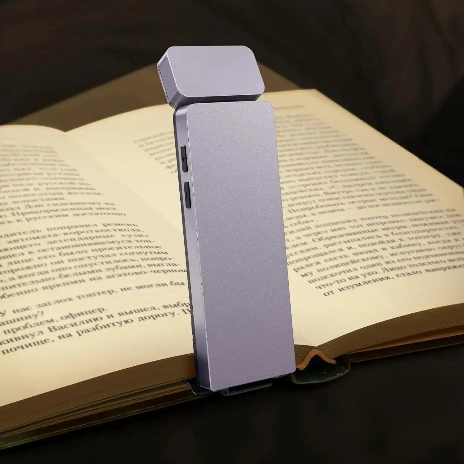 LED Rechargeable Clip-On Book Light in silver-gray perched on an open book