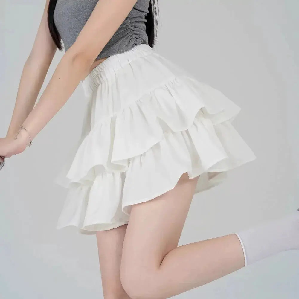 Mini white tiered A-line ruffle skirt with a high-waisted elastic waistband in kawaii Lolita style.