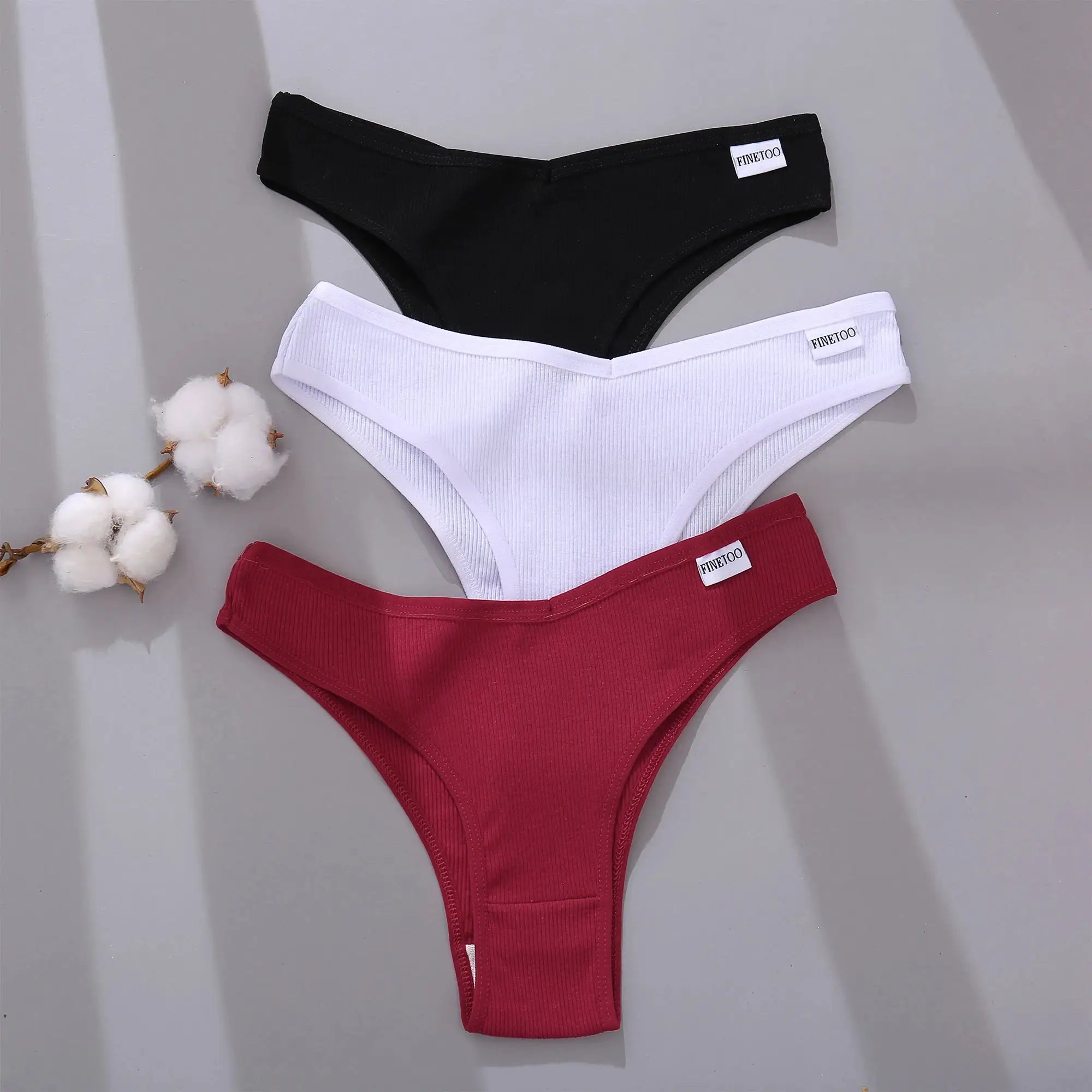 Three FINETOO cotton Brazilian panties set in black, white and red with V-waist and T-back design
