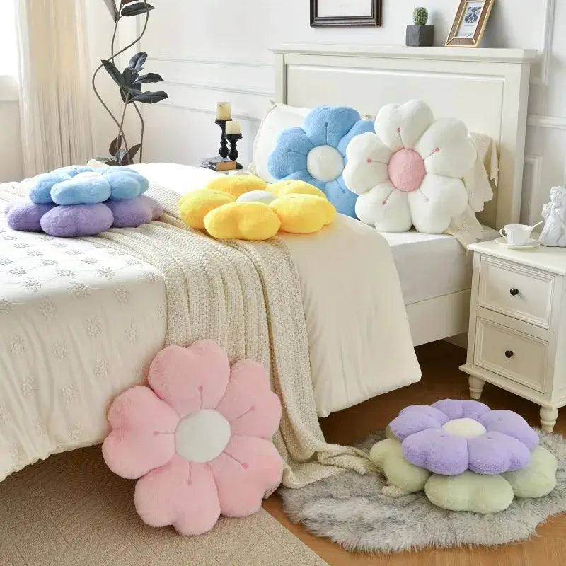 Flower-shaped plush throw pillows in pastel colors decorating bed and floor for cozy decor.
