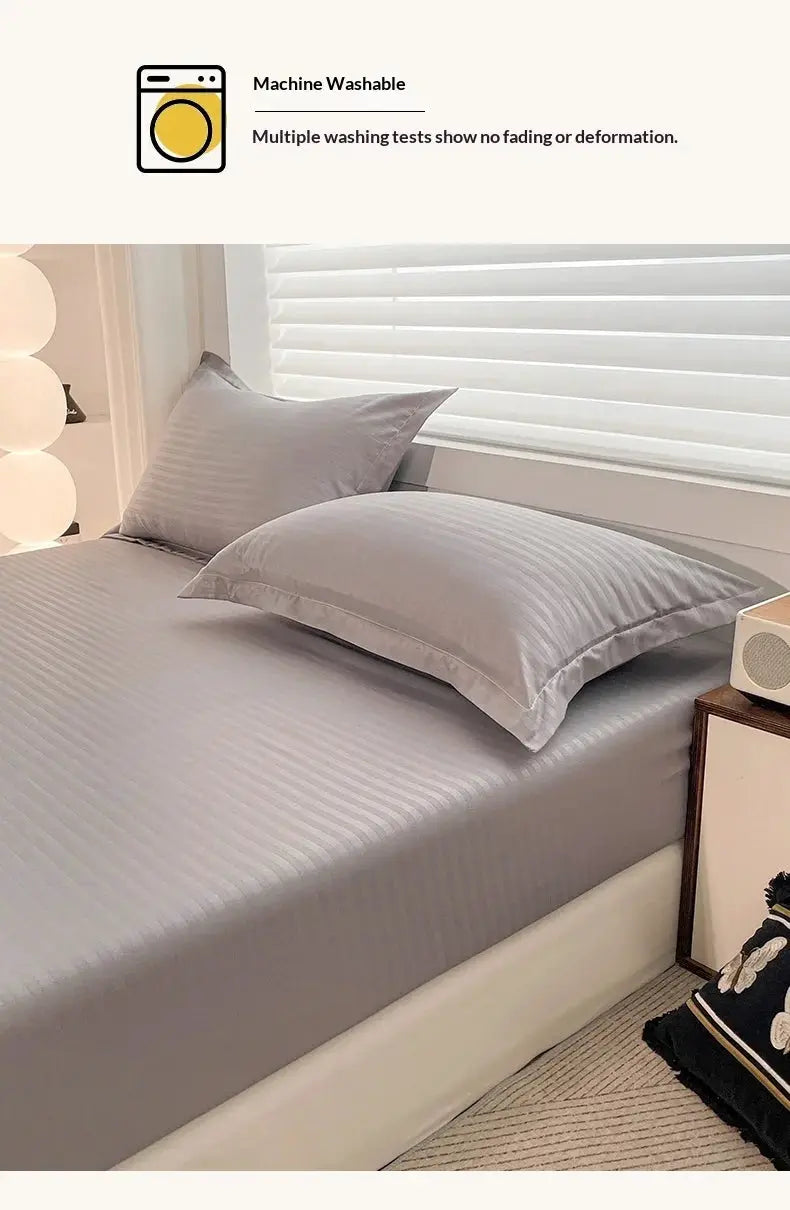 Simples Market fitted gray solid bed sheet with elastic band and 2 matching pillowcases on bed.